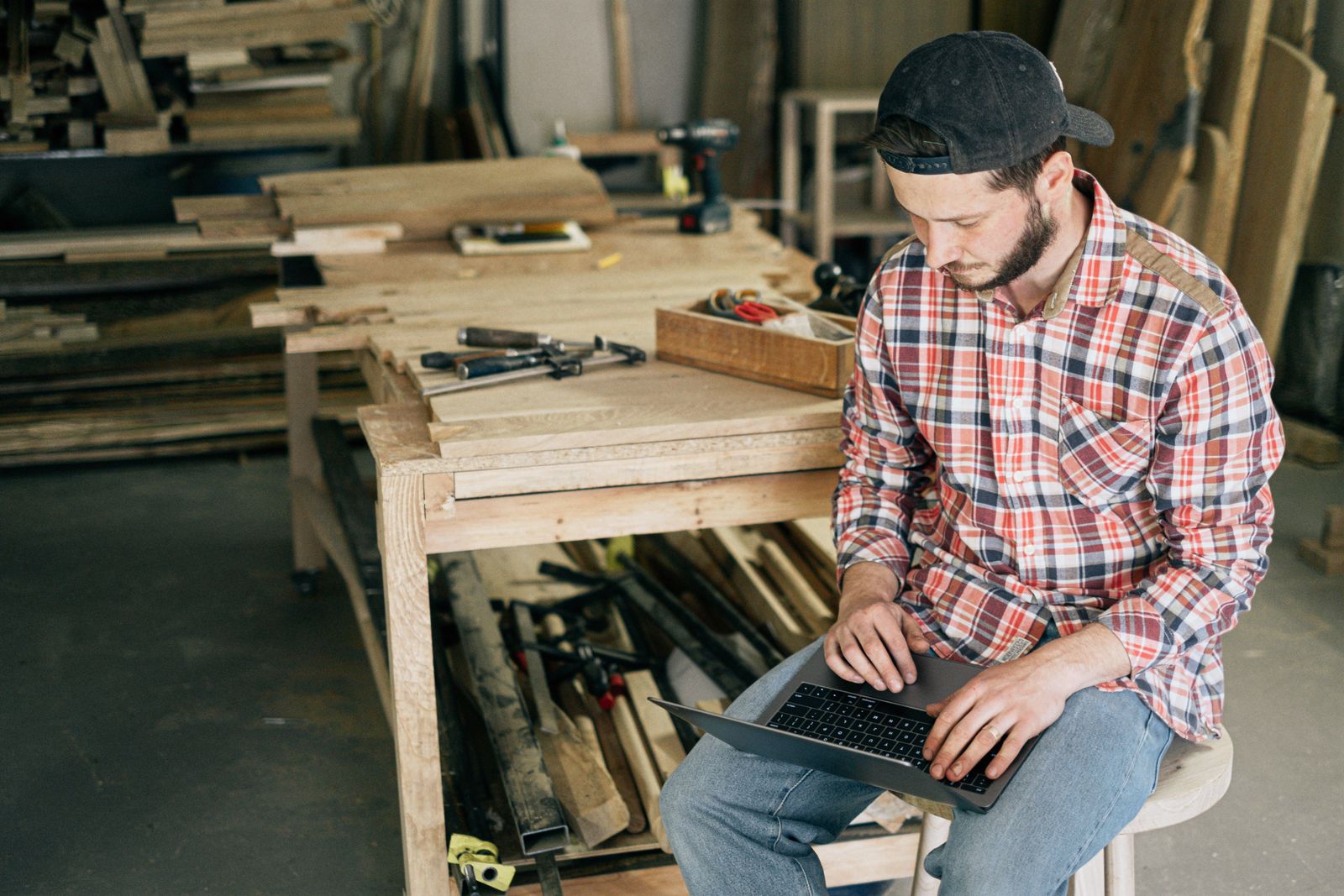 Handwerker arbeitet in seiner Werkstatt am Laptop